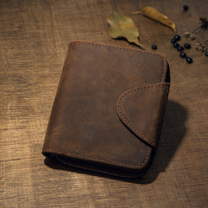 Vintage brown leather wallet, front view with flap, rustic wooden background