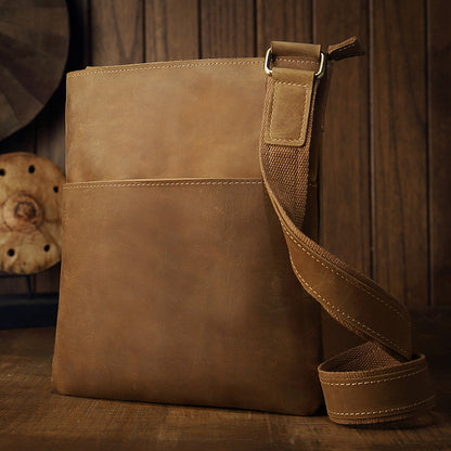 Brown leather crossbody bag, vintage design, wooden background