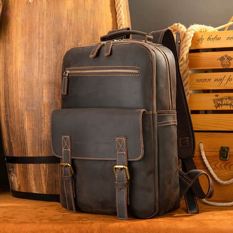 dark brown leather backpack, front view with buckle details, rustic background