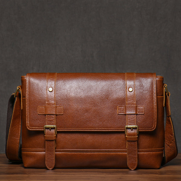 Vintage brown leather messenger bag, front view with buckle details, rustic background