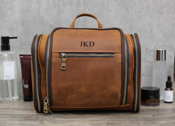 Brown leather toiletry bag, personalized "JKD", with grooming products around